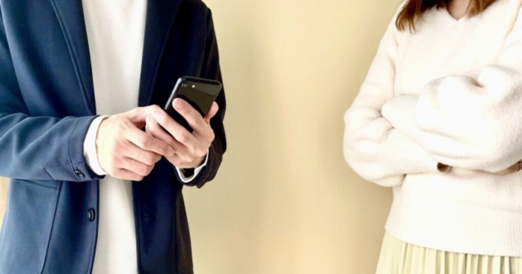 スマホを見つめる夫に疑念を抱く妻