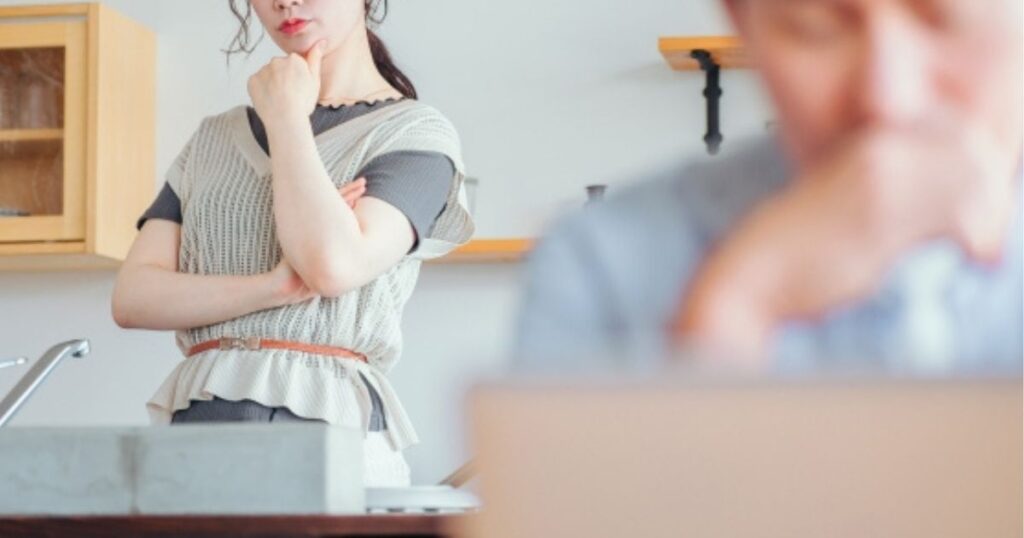 夫の姿を後ろから見つめる妻