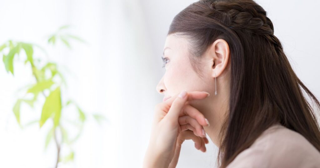 遠くを見つめ考えこむ女性