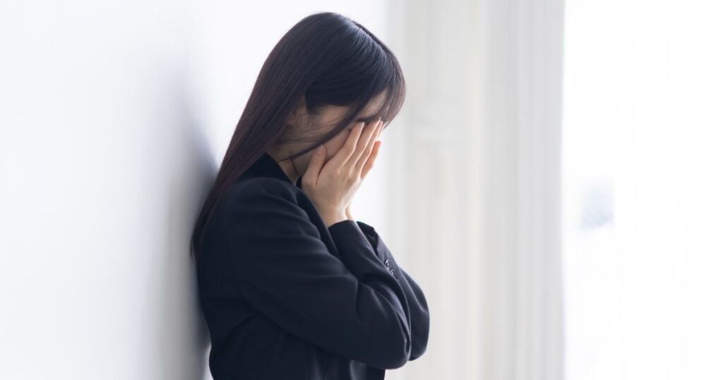 違法調査で訴えられて落ち込む女性